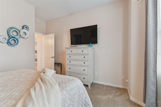 bedroom with light colored carpet and baseboards