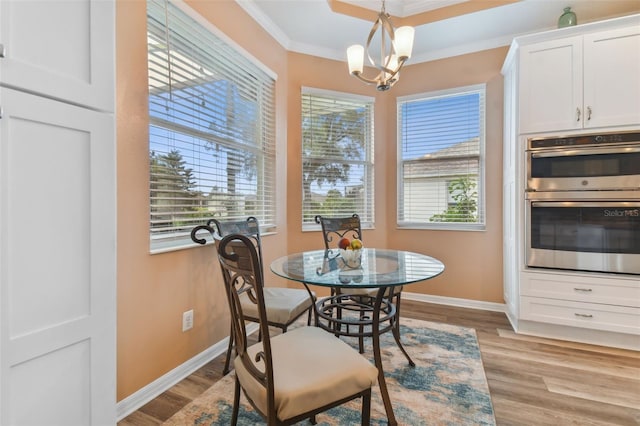 dining area with a chandelier, baseboards, light wood-style flooring, and crown molding