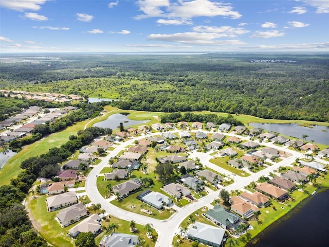 birds eye view of property featuring a forest view, a water view, and a residential view