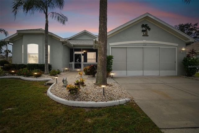 ranch-style house featuring a garage and a yard