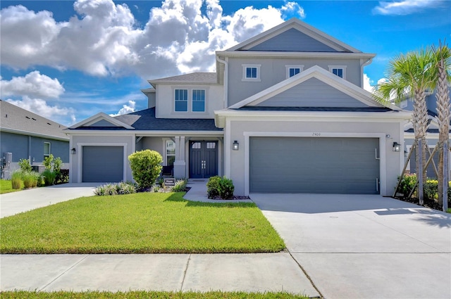 traditional-style house featuring a garage, concrete driveway, a front yard, and stucco siding