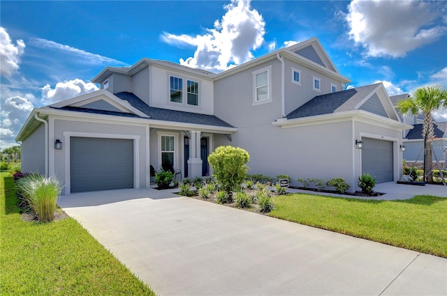 traditional home featuring a garage, driveway, a front lawn, and stucco siding