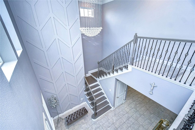 staircase with baseboards and an inviting chandelier