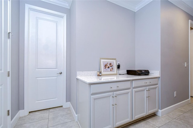 interior space with baseboards, tile patterned flooring, and crown molding