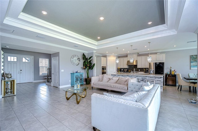 living area featuring light tile patterned flooring, recessed lighting, visible vents, baseboards, and a tray ceiling