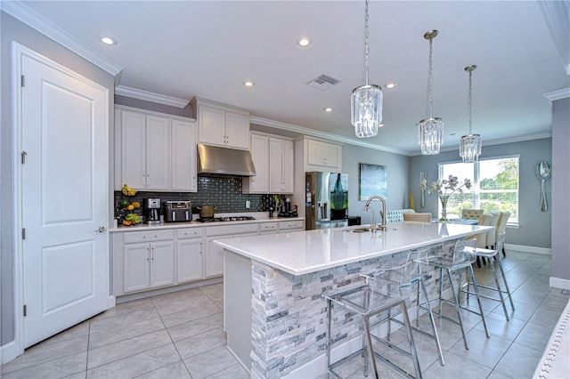 kitchen with a breakfast bar area, sink, a kitchen island with sink, and stainless steel appliances