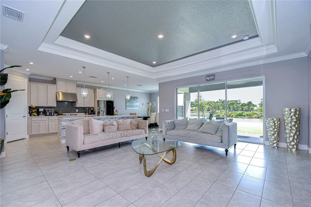 living area featuring a raised ceiling, visible vents, and light tile patterned floors