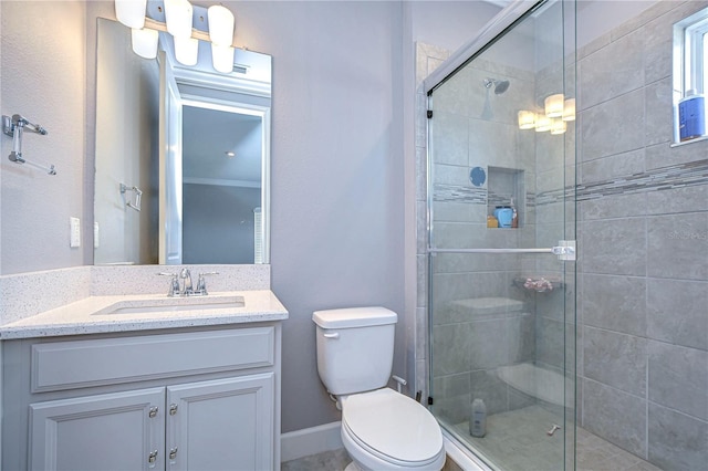 full bathroom with baseboards, a shower stall, toilet, and vanity