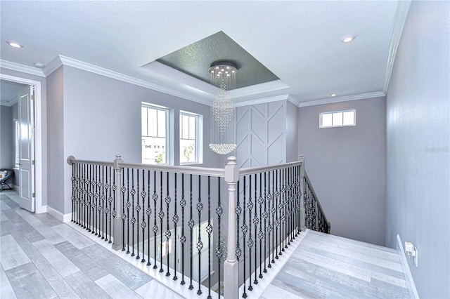 hallway with baseboards, crown molding, an upstairs landing, and an inviting chandelier