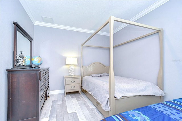 bedroom featuring a textured ceiling, ornamental molding, visible vents, and light wood-style floors