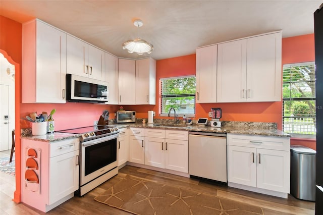 kitchen featuring stainless steel appliances, dark hardwood / wood-style floors, and white cabinetry