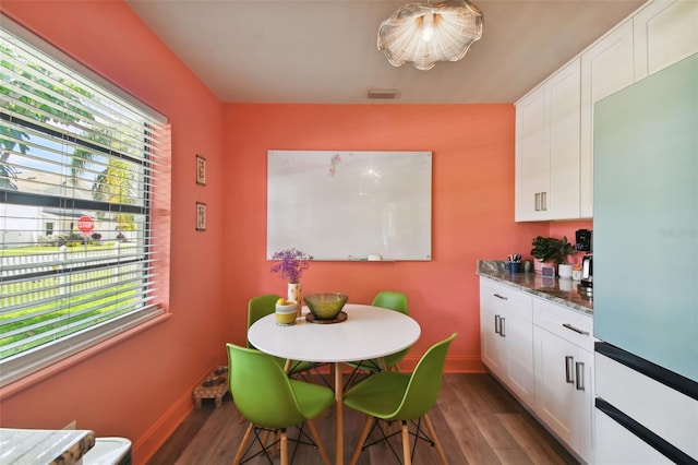 dining room with a healthy amount of sunlight and dark hardwood / wood-style floors