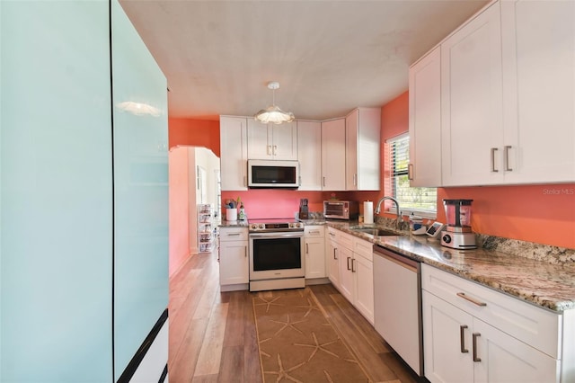 kitchen with white cabinets, wood-type flooring, stainless steel appliances, and sink