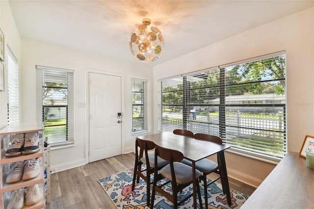 dining room with a healthy amount of sunlight, light hardwood / wood-style flooring, and a chandelier