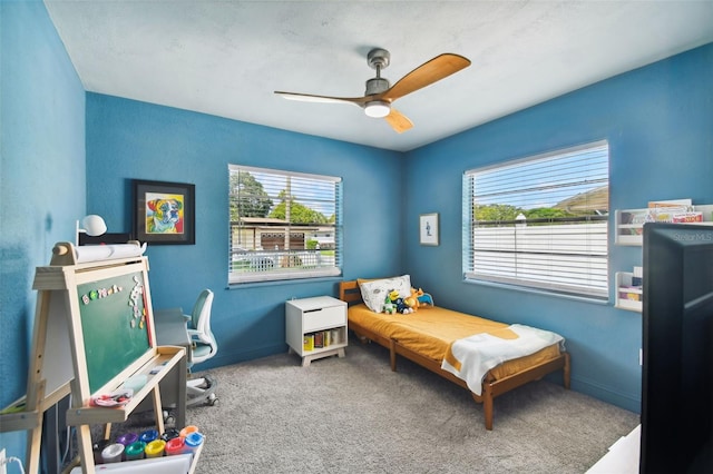 bedroom with ceiling fan, carpet floors, and multiple windows