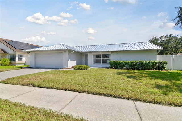 ranch-style home featuring a front lawn and a garage