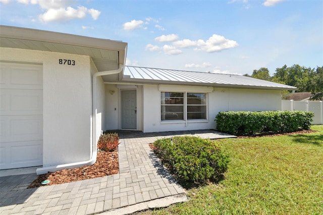 entrance to property with a lawn and a garage