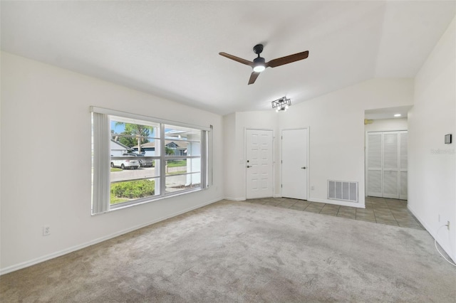 carpeted spare room featuring vaulted ceiling and ceiling fan