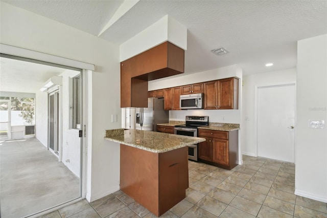 kitchen featuring a textured ceiling, kitchen peninsula, stainless steel appliances, light tile patterned floors, and light stone countertops