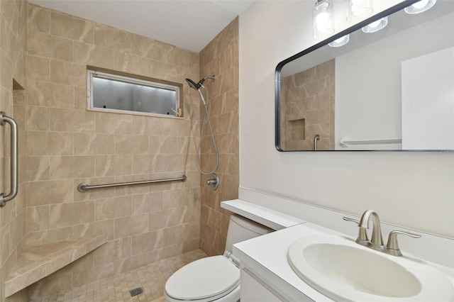 bathroom featuring tiled shower, vanity, and toilet