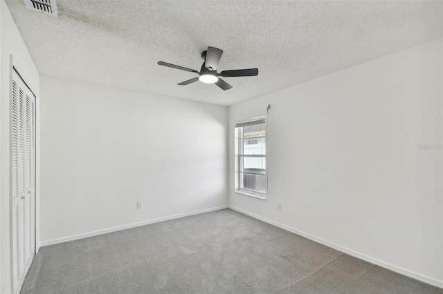 unfurnished bedroom featuring a closet, ceiling fan, carpet flooring, and a textured ceiling