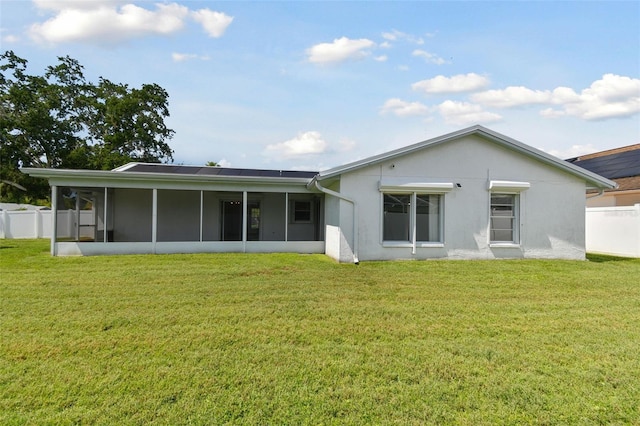 back of property featuring a sunroom and a lawn