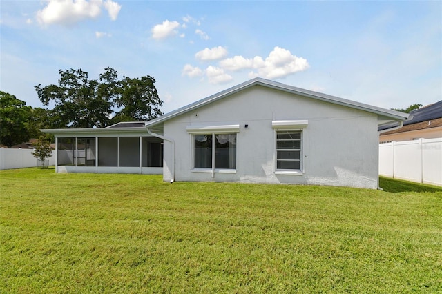 back of property featuring a yard and a sunroom