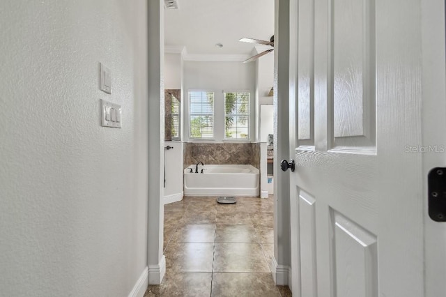 bathroom featuring ceiling fan, ornamental molding, tile patterned floors, and a washtub