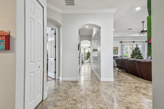 hall with crown molding and light tile patterned floors