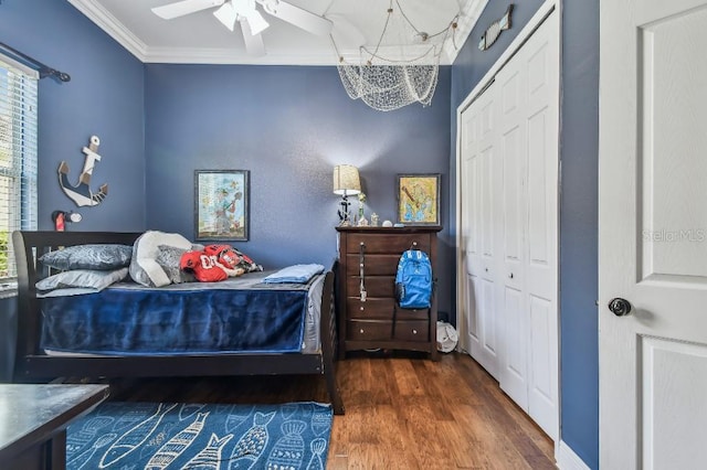 bedroom featuring crown molding, ceiling fan, dark wood-type flooring, and a closet