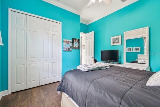 bedroom featuring dark wood-type flooring, ceiling fan, crown molding, and a closet