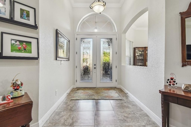 foyer entrance with ornamental molding and french doors