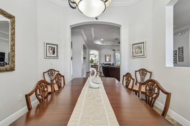 dining space featuring ornamental molding, a raised ceiling, and ceiling fan