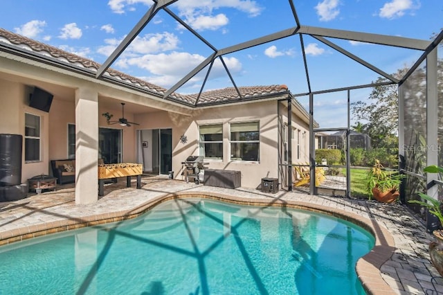 view of pool with a patio, ceiling fan, and glass enclosure