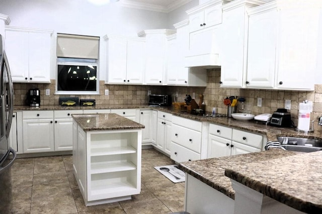 kitchen featuring white cabinetry, decorative backsplash, and a center island