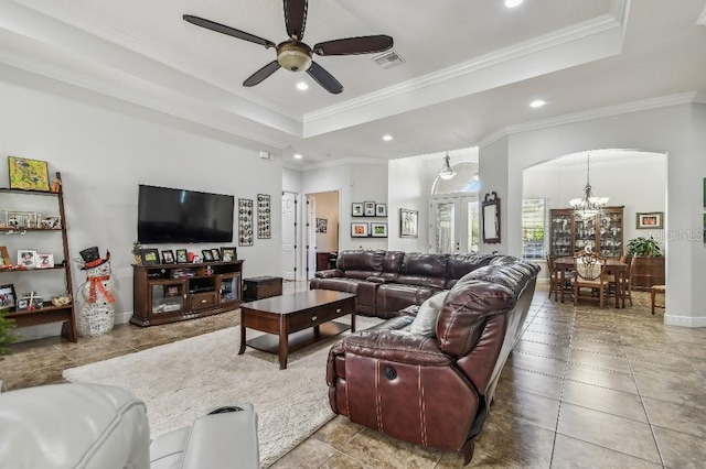 living room with crown molding, tile patterned flooring, a tray ceiling, and ceiling fan with notable chandelier