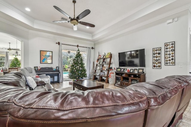 living room with a tray ceiling, plenty of natural light, and ceiling fan