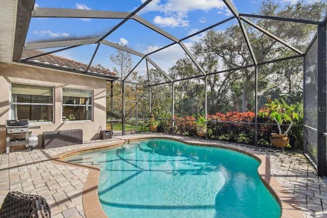 view of swimming pool featuring a lanai, grilling area, and a patio area