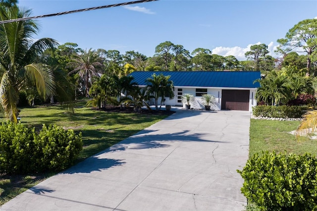 ranch-style house featuring a garage and a front yard