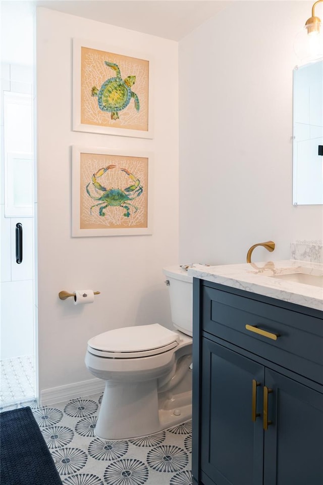 bathroom with vanity, toilet, walk in shower, and tile patterned floors