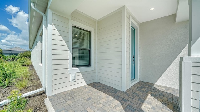 view of exterior entry with a patio