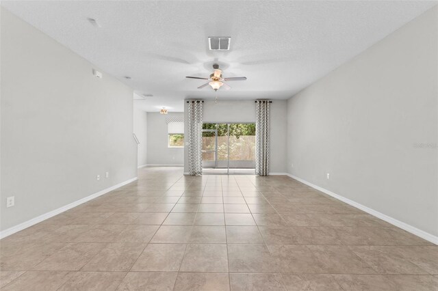 tiled spare room with a textured ceiling and ceiling fan