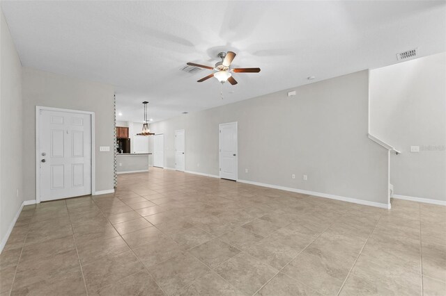 unfurnished living room with ceiling fan and light tile patterned floors