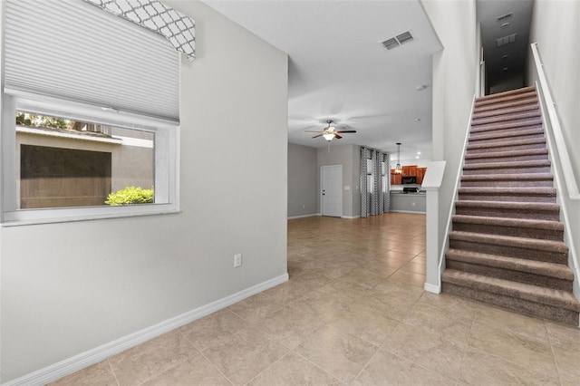 interior space with ceiling fan and light tile patterned flooring