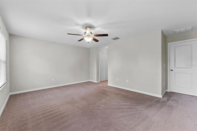 carpeted spare room featuring ceiling fan