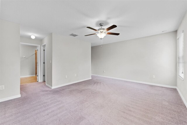 spare room featuring ceiling fan and light carpet