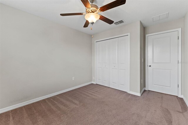 unfurnished bedroom with carpet flooring, a closet, and ceiling fan