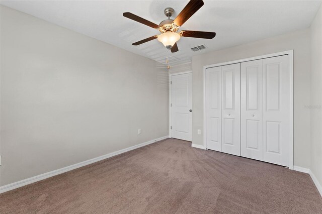 unfurnished bedroom with a closet, ceiling fan, and carpet