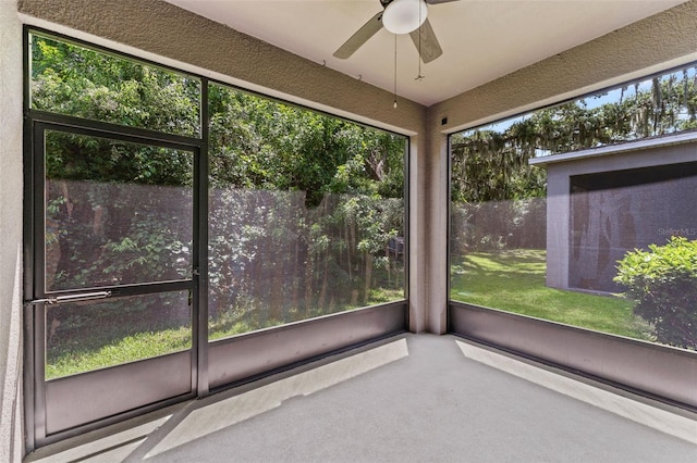 unfurnished sunroom with ceiling fan