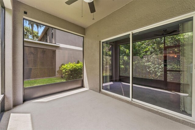 unfurnished sunroom with ceiling fan